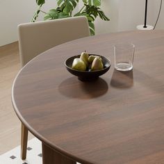 a bowl of fruit sitting on top of a wooden table