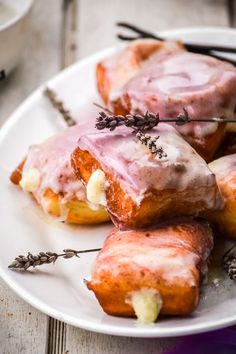 donuts with icing and lavender sprinkles on a white plate