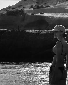 a woman in a bathing suit walking into the water