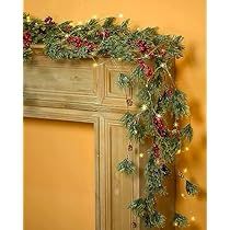 a fireplace decorated for christmas with garland and lights