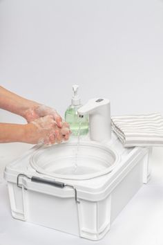 a person washing their hands with soap and lotion in front of a white background