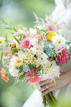 a bride holding a bouquet of flowers in her hands