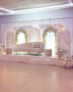 a white couch sitting on top of a floor next to a wall covered in flowers