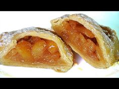 two pieces of fruit filled pastry sitting on top of a white plate