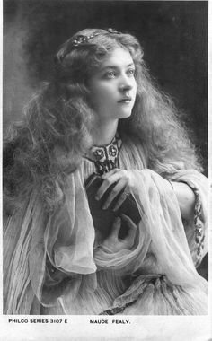 an old black and white photo of a woman with long hair wearing a veiled dress