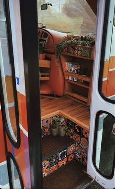 the interior of an rv with plants and potted plants on the door shelfs