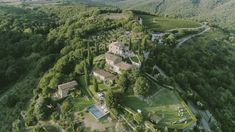 an aerial view of a large house surrounded by trees and greenery in the mountains