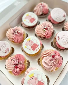 cupcakes decorated with pink and white frosting in a box