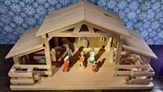 a wooden nativity scene with figurines in it