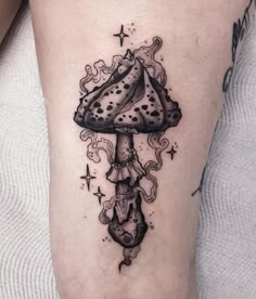 a black and white tattoo with a mushroom on the leg, stars in the background