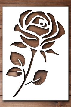 a paper cutout of a rose on a wooden background with the word love written in it