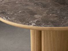 a marble topped table sitting on top of a hard wood floor next to a wall