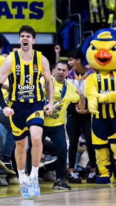 a basketball player is running on the court with his team mates in front of him