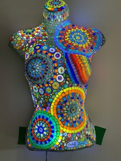 a mannequin made out of various colored circles on it's back and sides