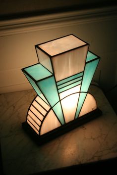 a table lamp sitting on top of a counter next to a white wall and window