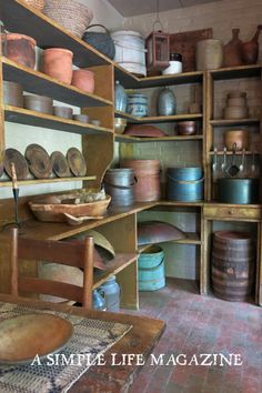 an old fashioned kitchen with lots of pots and pans on the shelves in it