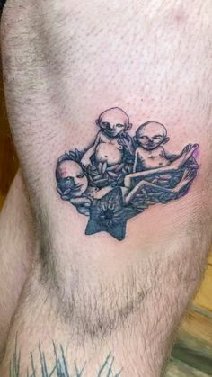 a man's stomach with an alien tattoo on it