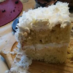 a piece of cake sitting on top of a wooden cutting board