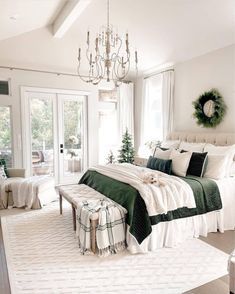 a white and green bedroom with a chandelier