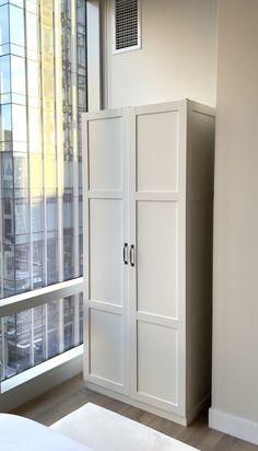 a white cabinet next to a window in a room