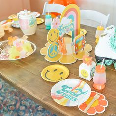 a wooden table topped with lots of plates and paper cutouts on top of it