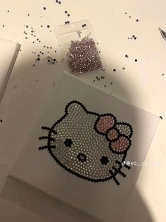 a hello kitty sticker on top of a white table next to a pen and scissors