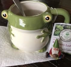 a green frog mug sitting on top of a table