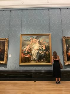 a woman standing in front of a painting