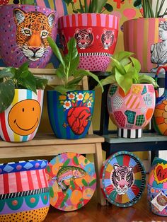 brightly painted pots with plants and animals on them