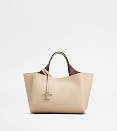 Bag in soft exposed grain leather, with Tod's logo stamped on the front, flat handles and removable shoulder strap. The interior comes with three compartments separated by zipped central pockets. An elegant creation enhanced by distinctive iconic detailing, such as the metal T Timeless pendant and T-stitching. Tan Calf Leather Bag With Removable Pouch, Tan Calf Leather Bag With Top Carry Handle, Beige Calf Leather Bag With Top Carry Handle, Tan Calf Leather Shoulder Bag With Double Handle, Tan Calf Leather Bag With Double Handle, Tan Top Handle Shoulder Bag In Soft Leather, Cream Rectangular Calf Leather Bag, Tan Calf Leather Crossbody Bag, Leather Bag With Detachable Handle In Tan