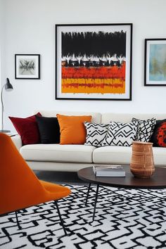 a living room filled with furniture and pictures on the wall above it's coffee table