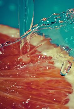 an orange slice with water splashing on it