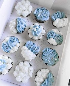 a box filled with blue and white cupcakes