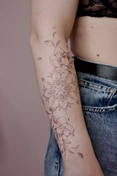 a woman with a flower tattoo on her arm