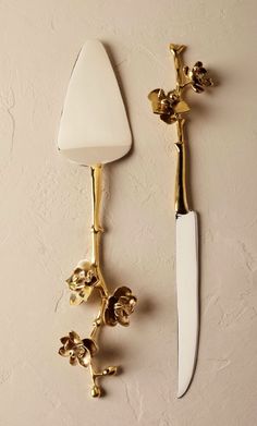 a knife is hanging on the wall next to a candle holder with a flower design