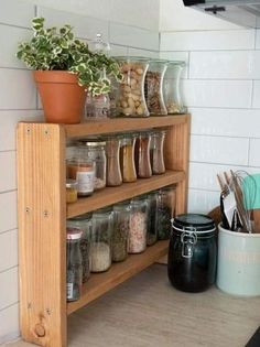 a wooden shelf filled with lots of jars and containers next to a potted plant