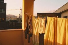 clothes hanging out to dry on a line outside the building with buildings in the background