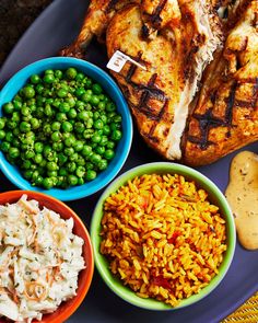 a plate with rice, peas, chicken and other food items on top of it