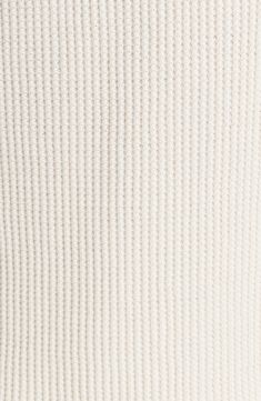 the back of a white sweater that is folded up to show it's ribbing