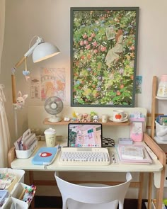 a desk with a computer, keyboard and mouse on it in front of a painting