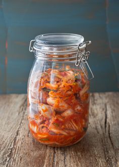 a glass jar filled with food sitting on top of a wooden table