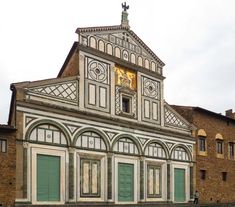 an old building with green shutters and a clock tower