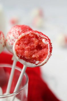 two candy lollipops sitting on top of each other in a glass cup