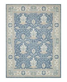 a blue and white rug with an intricate design on the bottom, in front of a white background