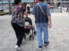 a man and woman walking with a stroller