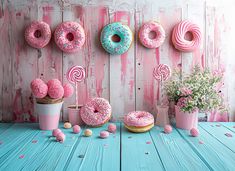 pink donuts with sprinkles and candies on blue wooden table