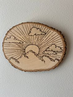 a piece of wood that has been carved into the shape of a sun and clouds