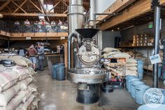 an industrial factory with people working in the background and lots of bags on the floor