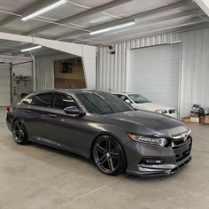 a grey car parked in a garage next to other cars