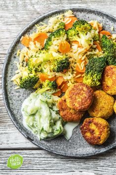 a plate full of food with broccoli, carrots and rice on it